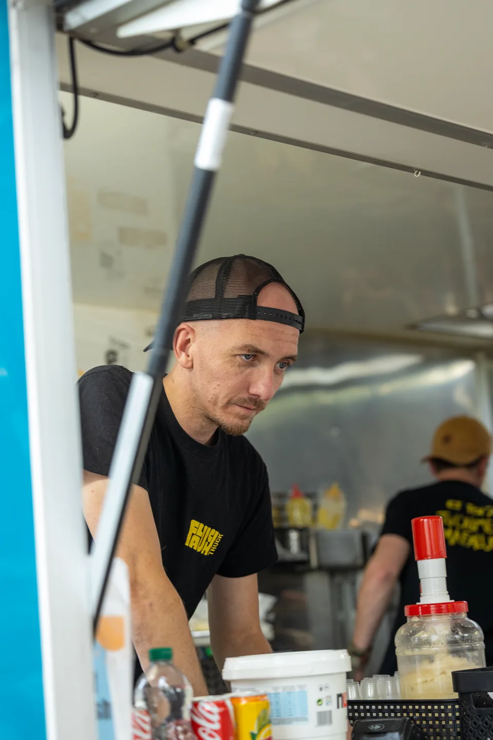 Une personne au travail au comptoir d’un food truck aux Masters de Feu